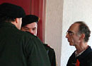 KPÖ-Finanzchef Graber mit zwei Polizeibeamten