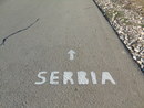 Von Aktivist_innen angebrachter Wegweiser nach Serbien